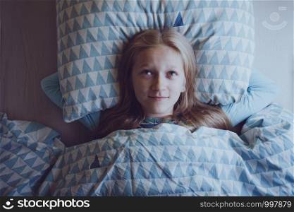 little girl lies in bed and dreams before bedtime. sleep and health