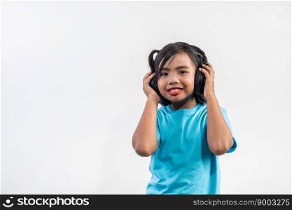 Little girl listening to music on wireless headphones 