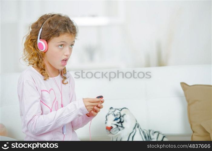 Little girl listening to music through headphones