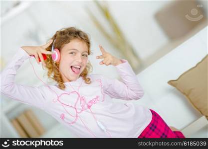 Little girl listening to music through headphones