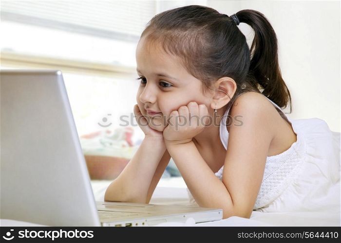Little girl looking at a laptop
