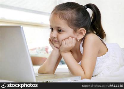 Little girl looking at a laptop