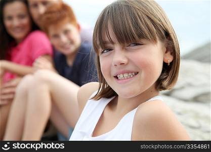 Little girl looking at camera and family in background