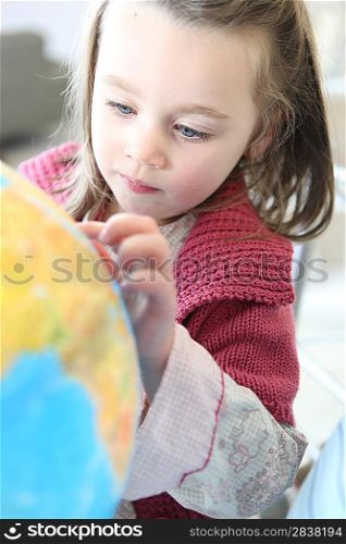 Little girl looking at globe