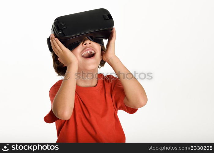 Little girl looking in VR glasses and gesturing with his hands. Cheerful surprised child wearing virtual reality goggles watching movies or playing video games, isolated on white background.