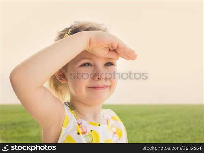 Little girl looking worward with the hand in forehead