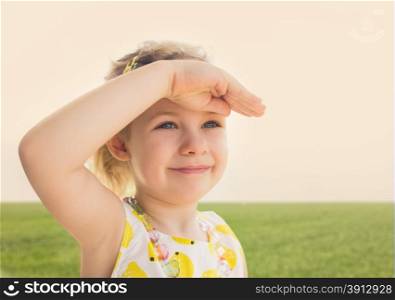 Little girl looking worward with the hand in forehead
