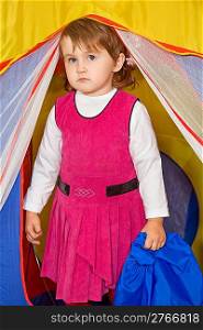 little girl looks out of tourist tent