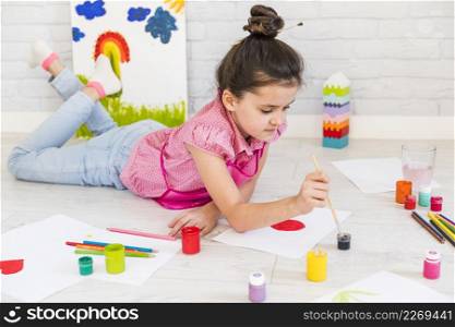 little girl lying floor painting with water color with paint brush paper