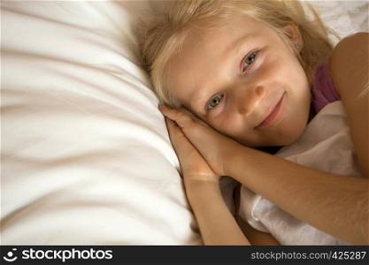 little girl lying in bed