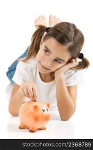 Little girl lying on floor and inserting a one euro coin on the piggy-bank