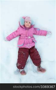 Little girl lying on snow