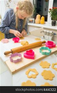 little girl makes a cookie in the kitchen