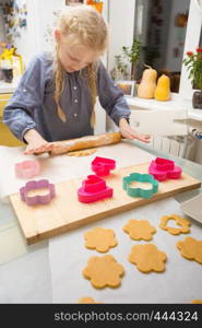 little girl makes a cookie in the kitchen