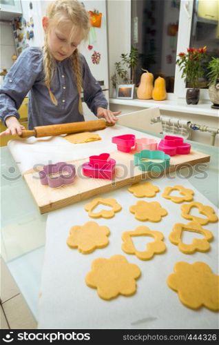 little girl makes a cookie in the kitchen