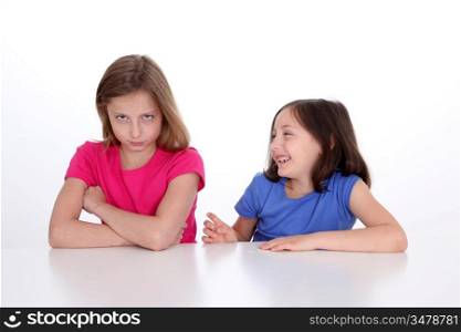 Little girl making fun of her sister
