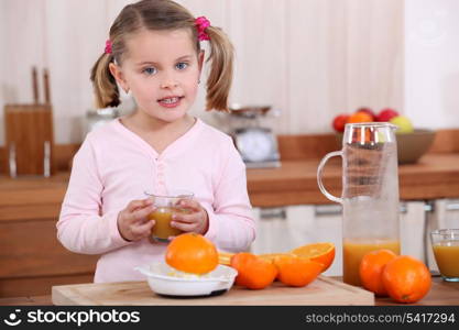 Little girl making orange juice.