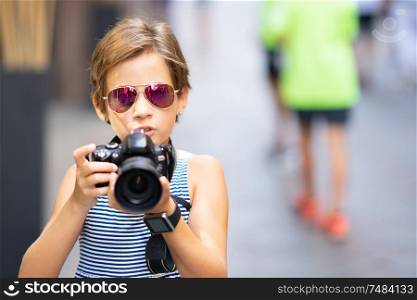 Little girl making photo with DSLR camera on city street. Small female traveling in urban background.. Little girl making photo with DSLR camera on city street