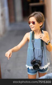 Little girl making photo with DSLR camera on city street. Small female traveling in urban background.. Little girl making photo with DSLR camera on city street