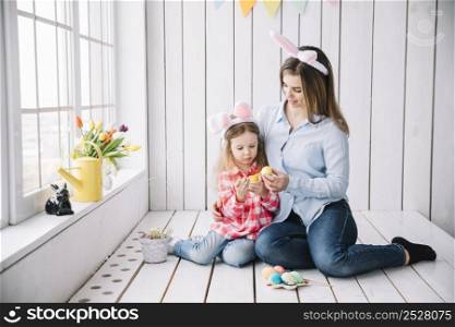 little girl mother bunny ears painting eggs easter
