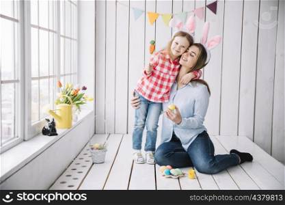 little girl mother bunny ears sitting with easter eggs