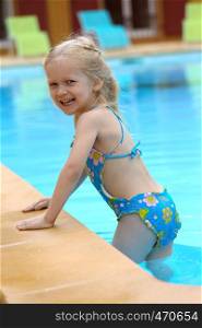 little girl near the open-air swimming pool