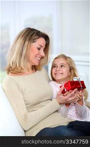 Little girl offering present to her mom