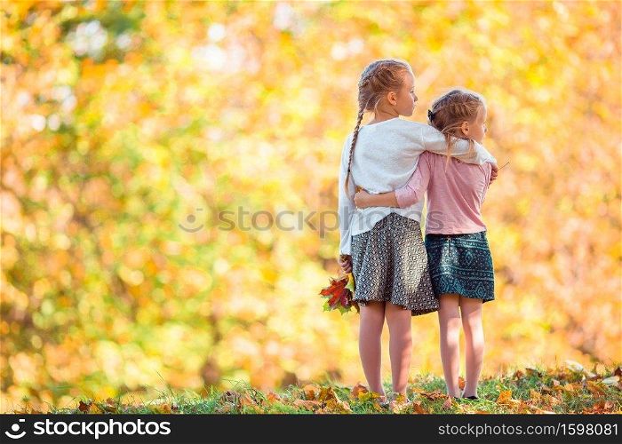 Little girl on beautiful autumn day. Little adorable girls outdoors at warm sunny autumn day