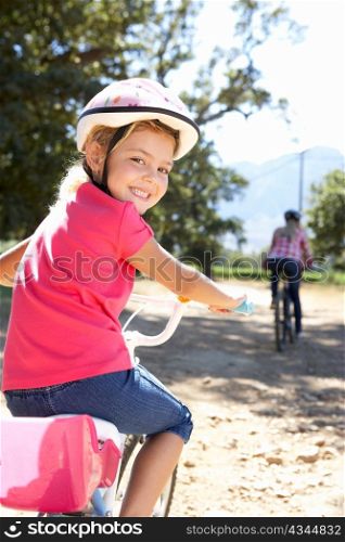 Little girl on country bike ride with mom