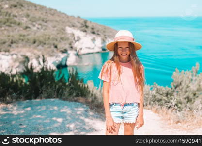 Little girl on summer vacation background of beautiful San Felice arch Architello on Gargano coast. Little girl on vacation travel background beautiful landscape