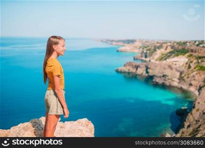 Little girl on summer vacation in mountains. Kid on vacation on white rock background