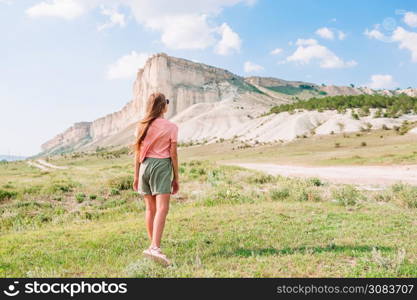 Little girl on summer vacation in mountains. Kid on vacation on white rock background