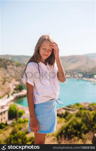 Little girl on top of a mountain enjoying valley view. Beautiful girl with overlooking the bay. Beautiful girl with overlooking the bay