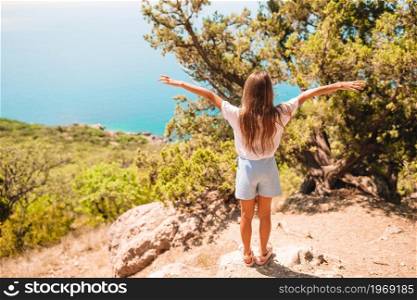 Little girl on top of a mountain enjoying valley view. Beautiful girl with overlooking the bay. Beautiful girl with overlooking the bay