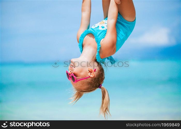 Little girl on white sandy beach have fun with his dad. Little girl and happy dad having fun during beach vacation