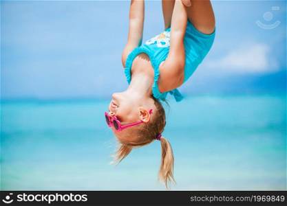 Little girl on white sandy beach have fun with his dad. Little girl and happy dad having fun during beach vacation