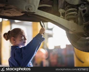 little girl overall inspecting car with magnifier