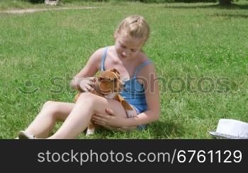 Little girl owner with american staffordshire terrier puppy dog on grass