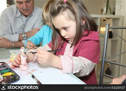 Little girl painting a figurine