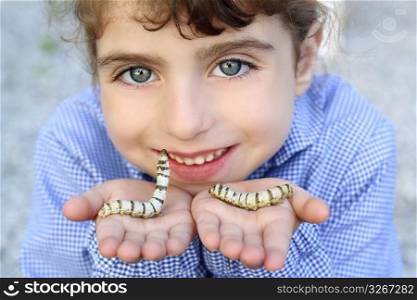 little girl palying with silkworm in hands with school uniform