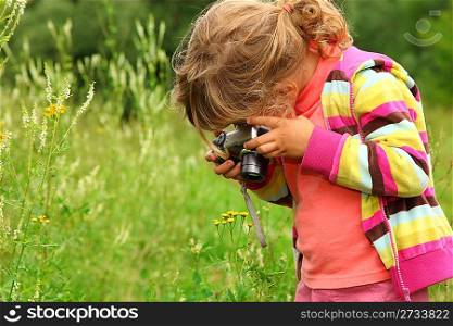 little girl photographs flower outdoor