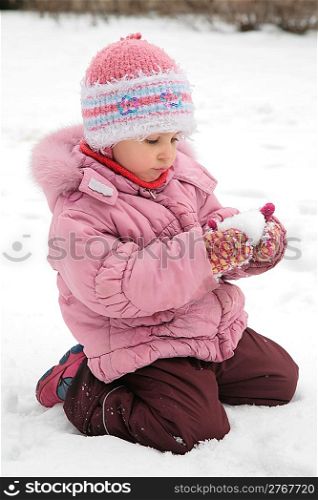 little girl play with snow in winter