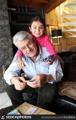 Little girl playing cards with grandpa
