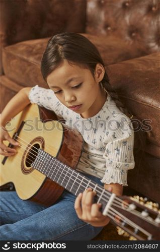 little girl playing guitar home