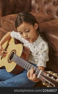 little girl playing guitar home