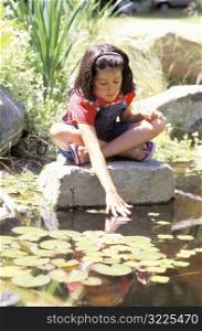 Little Girl Playing in Pond