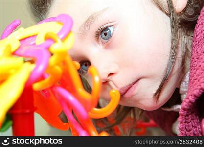 Little girl playing with a plastic toy