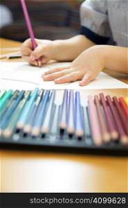 little girl playing with colors. The focus is on the hand lying on the paper