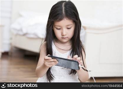 Little girl playing with her cell phone