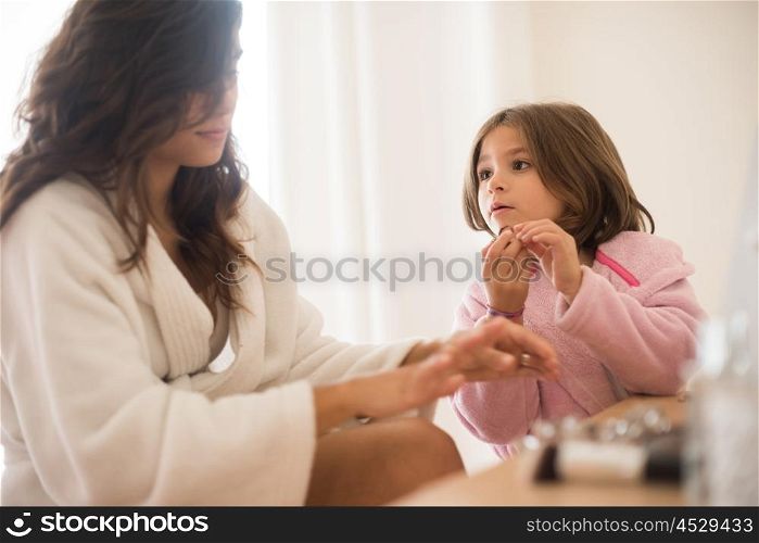 Little girl playing with her mother jewellery and make up